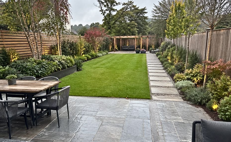 Contemporary evening garden with layered lighting and planting